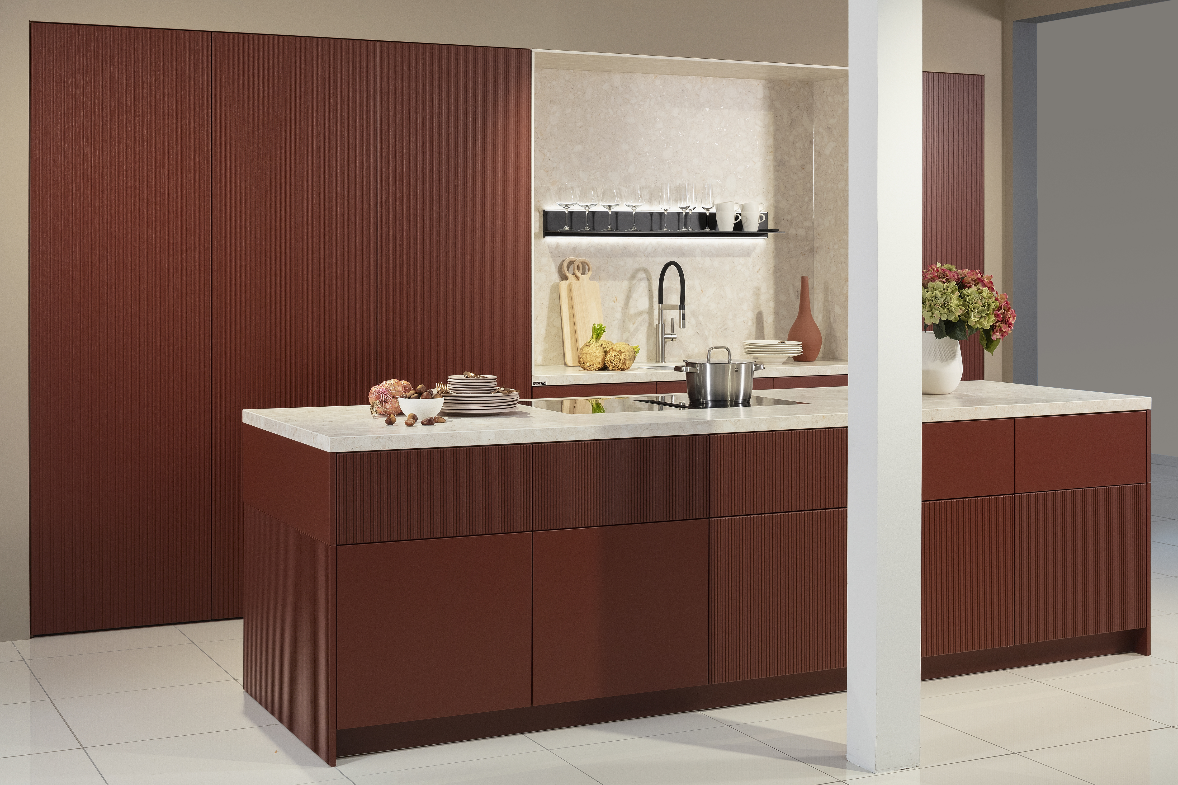 Küchenzeile mit Kücheninsel in Samtlack rot und weißer Arbeitsplatte, mit geschossener Schrankwand. 